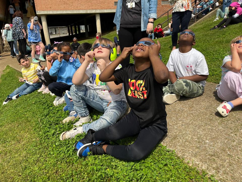 (Front) Pharoah Taylor and Krew Stewart carefully hold on to their protective eye glasses as they watch the eclipse with their class at Riverside Elementary School on April 8, 2024 in Columbia, Tenn.