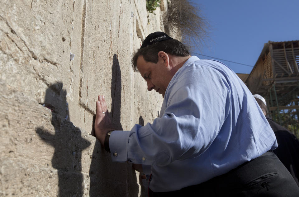 New Jersey Gov. Chris Christie touches the stones of the Western Wall, the holiest site where Jews can pray, during his visit to Jerusalem's old city, Monday, April 2, 2012. Christie kicked off his first official overseas trip Monday meeting Israel's leader in a visit that may boost the rising Republican star's foreign policy credentials ahead of November's presidential election. (AP Photo/Sebastian Scheiner)