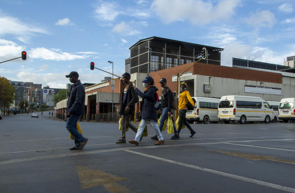 Pedestrians walks on the street in downtown Johannesburg, South Africa, Thursday, April 9, 2020. South Africa and more than half of Africa's 54 countries have imposed lockdowns, curfews, travel bans or other restrictions to try to contain the spread of COVID-19. The new coronavirus causes mild or moderate symptoms for most people, but for some, especially older adults and people with existing health problems, it can cause more severe illness or death. (AP Photo/Themba Hadebe)