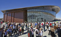 FILE - In this Oct. 17, 2011 file photo, guests stand outside the new Spaceport America hangar in Upham, N.M. Virgin Galactic is scheduled to unveil the interior of its digs at Spaceport America, providing the first glimpse of mission control, a prep area for pilots and where paying customers will lounge ahead of their suborbital flights. Company officials are gathering Thursday, Aug. 15, 2019, at the remote facility in the New Mexico desert to show off two levels of the custom-tailored hangar at the taxpayer-financed spaceport. (AP Photo/Matt York, File)