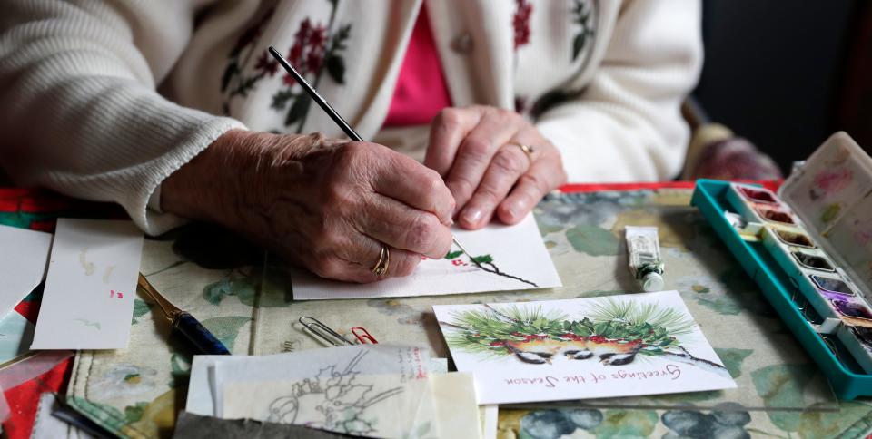 Germaine Smith, who turned 100 on Jan. 8, paints a greeting card using water colors while sitting at her kitchen table on Jan. 18, 2023, in Wrightstown, Wis.