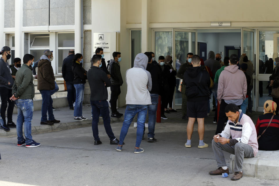 People gather at the emergency entrance a coronavirus testing center in the Rafik Hariri University Hospital in Beirut, Lebanon, Monday, Jan. 11, 2021. Lebanon's caretaker prime minister said Monday the country has entered a "very critical zone" in the battle against coronavirus as his government mulls tightening nationwide lockdown announced last week. (AP Photo/Bilal Hussein)