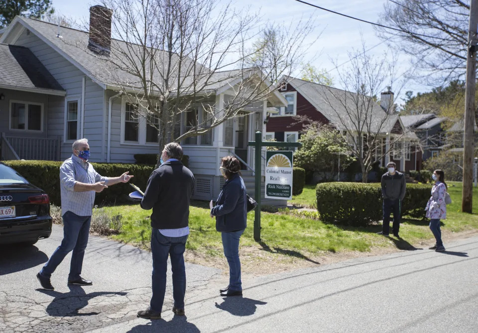 Rick Nazarro of Colonial Manor Realty talks with a pair of interested buyers in the driveway as a couple waits to enter a property he is trying to sell during an open house in Revere, MA. (Credit: Blake Nissen for The Boston Globe via Getty Images)