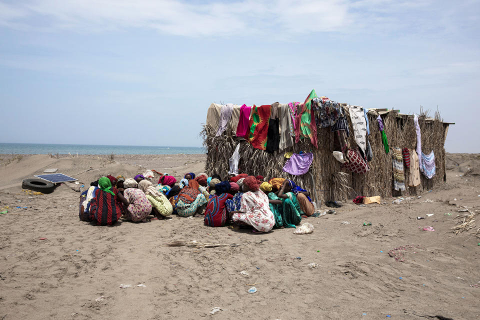 In this July 26, 2019 photo, Ethiopian migrant girls eat outside their lockup known in Arabic as a "hosh," in Ras al-Ara, Lahj, Yemen. Some lockups hold as many as 50 women at a time. The women will stay here for several days until their transportation is ready. (AP Photo/Nariman El-Mofty)