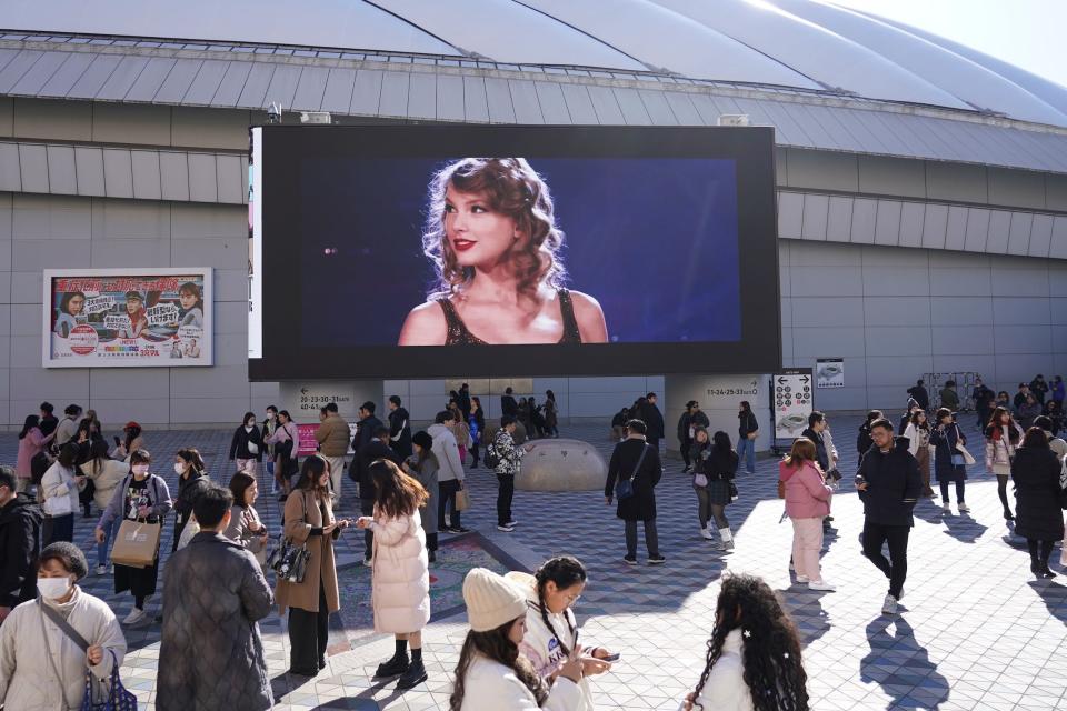 A screen outside a stadium with Taylor Swift's face on it