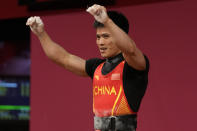 Li Fabin of China celebrates after a lift as he competes in the men's 61kg weightlifting event, at the 2020 Summer Olympics, Sunday, July 25, 2021, in Tokyo, Japan. (AP Photo/Luca Bruno)