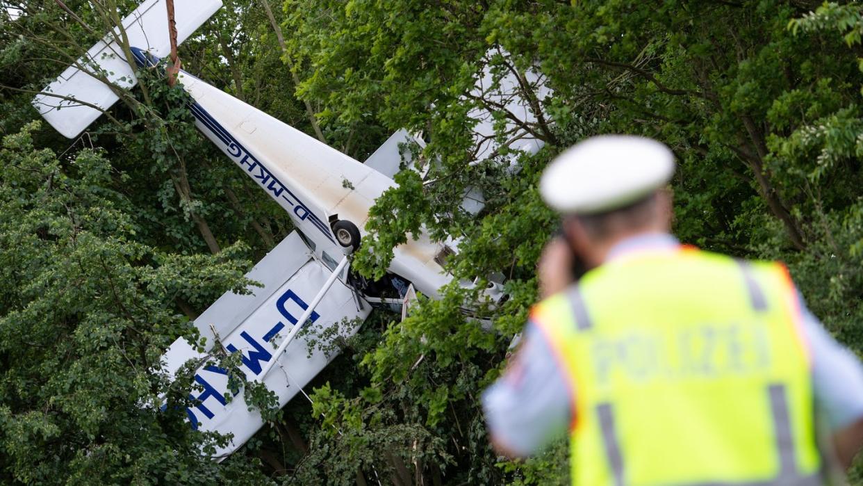 Ein Kleinflugzeug hängt neben einem Flugfeld in den Bäumen. Die beiden Insassen wurden in ein Krankenhaus gebracht. Foto: Marius Becker