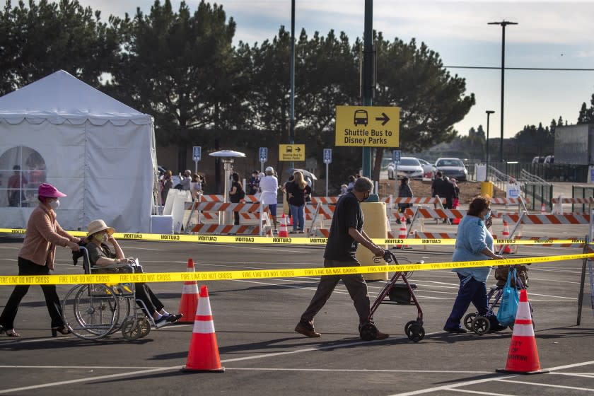 Anaheim, CA - January 13: Orange County active Phase 1A (critical and healthcare workers) residents exit large tents at Orange County's first large-scale vaccination site after receiving the Moderna COVID-19 vaccine in the Toy Story parking lot at the Disneyland Resort in Anaheim Wednesday, Jan. 13, 2021. Orange County supervisors and Orange County Health Care Agency Director Dr. Clayton Chau held a news conference discussing the county's first Super POD (point-of-dispensing) site for COVID-19 vaccine distribution. The vaccinations are at Tier 1A for people who have reservations on a website. The site is able to handle 7,000 immunizations per day. Their goal is to immunize everyone in Orange County who chooses to do so by July 4th. (Allen J. Schaben / Los Angeles Times)