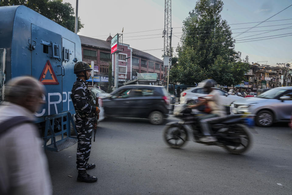 An Indian paramilitary soldier guards as traffic moves at a busy market in Srinagar, Indian controlled Kashmir, Tuesday, Aug 1, 2023. India’s top court Wednesday began hearing a clutch of petitions challenging the constitutionality of the legislation passed by Prime Minister Narendra Modi’s government in 2019 that stripped disputed Jammu and Kashmir’s statehood, scrapped its separate constitution and removed inherited protections on land and jobs. (AP Photo/Mukhtar Khan)