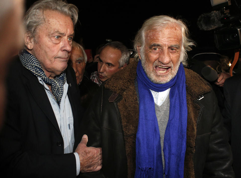 FILE - In this Nov. 17, 2017 file photo, French actors Alain Delon, left, and Jean-Paul Belmondo arrive for the inauguration of a giant Ferris wheel, in Paris. French New Wave actor Jean-Paul Belmondo has died, according to his lawyer’s office on Monday Sept. 6, 2021. (AP Photo/Thibault Camus, File)