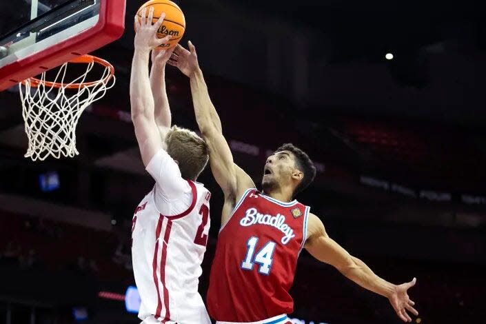 Bradley Braves forward and MVC Defensive Player of the Year Malevy Leons tries to block a shot from Wisconsin center Steven Crowl during BU's 81-62 loss in the first round of the NIT at Kohl Center in Madison, Wis., on Tuesday, March 14, 2023.