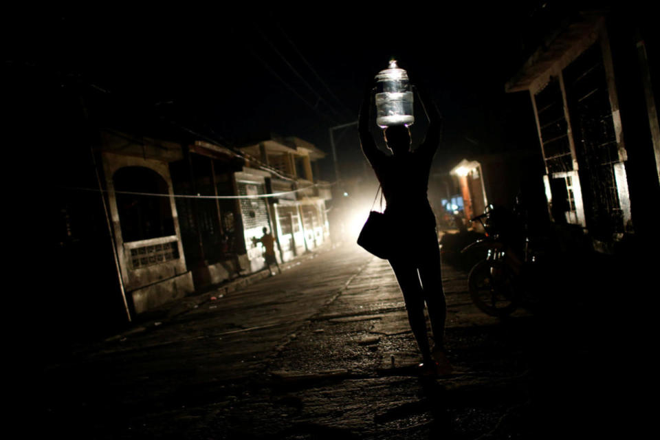 <p>A woman carries a plastic container filled with water after Hurricane Matthew hit Jeremie, Haiti, October 11, 2016. (Carlos Garcia Rawlins/Reuters)</p>