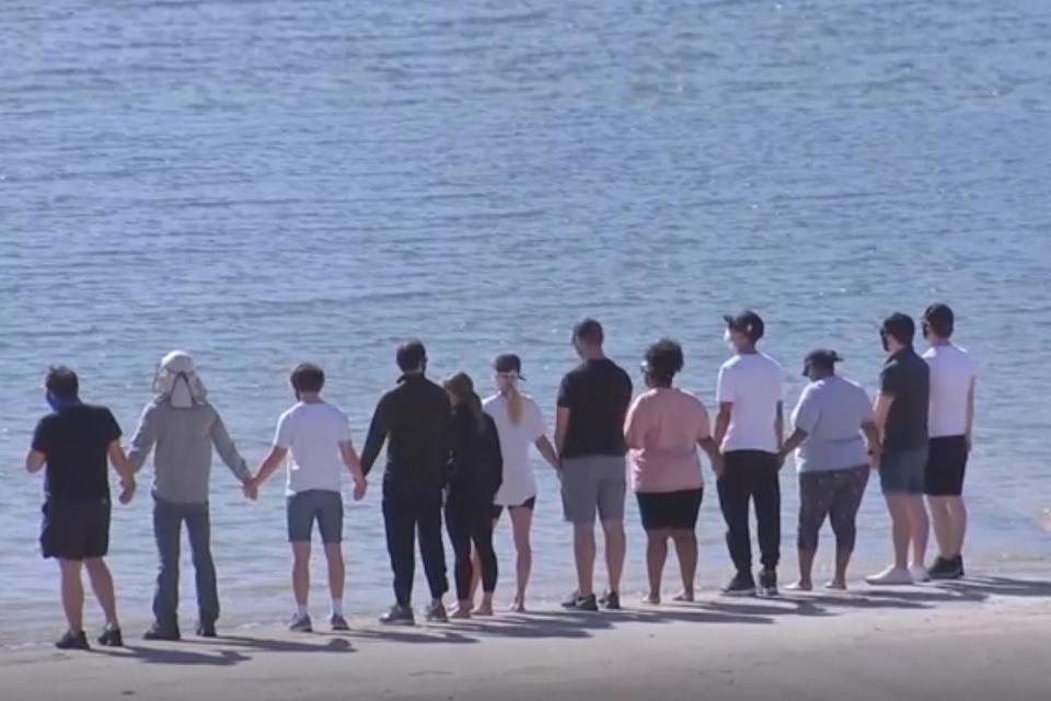 In mourning: The Glee cast joined hands by the lake where Rivera's body was recovered (ABC)