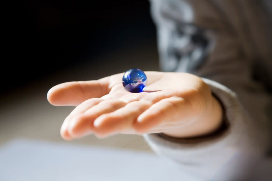 A glass marble on a person’s hand (Getty Images)