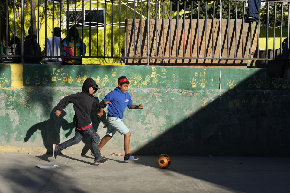 Migrant children play soccer at a shelter Wednesday, Dec. 21, 2022, in Tijuana, Mexico. Thousands of migrants gathered along the Mexican side of the southern border Wednesday, camping outside or packing into shelters as they waited for the U.S. Supreme Court to decide whether and when to lift pandemic-era restrictions that have prevented many from seeking asylum. (AP Photo/Marcio Jose Sanchez)