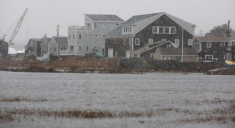 High winds at high tide push water over a sea wall and into low-lying areas of the Brant Rock neighborhood of Marshfield on Tuesday, Feb. 13, 2024.