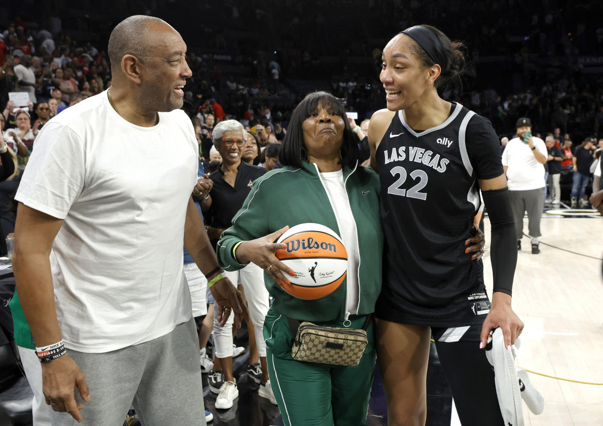 Las Vegas Aces center A'ja Wilson (22) celebrates with her parents Roscoe and Eva Wilson after an WNBA basketball game against the Connecticut Sun, Sunday, Sept. 15, 2024, in Las Vegas. (Steve Marcus/Las Vegas Sun via AP)