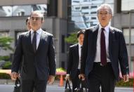 Former Nissan Motor Co. Chairman Carlos Ghosn and his lawyer Junichiro Hironaka arrive at the Tokyo District Court for the first pretrial procedures in his financial misconduct case, in Tokyo