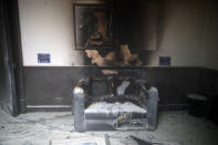 A couch and art work destroyed by fire are seen inside the Congress building after protesters set a part of building on fire, in Guatemala City, Saturday, Nov. 21, 2020. Hundreds of protesters were protesting in various parts of the country Saturday against Guatemalan President Alejandro Giammattei and members of Congress for the approval of the 2021 budget that reduced funds for education, health and the fight for human rights. (AP Photo/Moises Castillo)