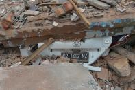 <p>A crushed car is seen under rubble of a house collapsed after the earthquake in Tanjung on Lombok island on Aug. 9, 2018. (Photo: Adek Berry/AFP/Getty Images) </p>