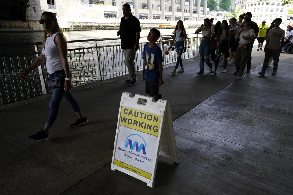 People walk along the Chicago Riverwalk, Monday, July 3, 2023, a day after heavy rains flooded Chicago streets and neighborhoods. (AP Photo/Nam Y. Huh)