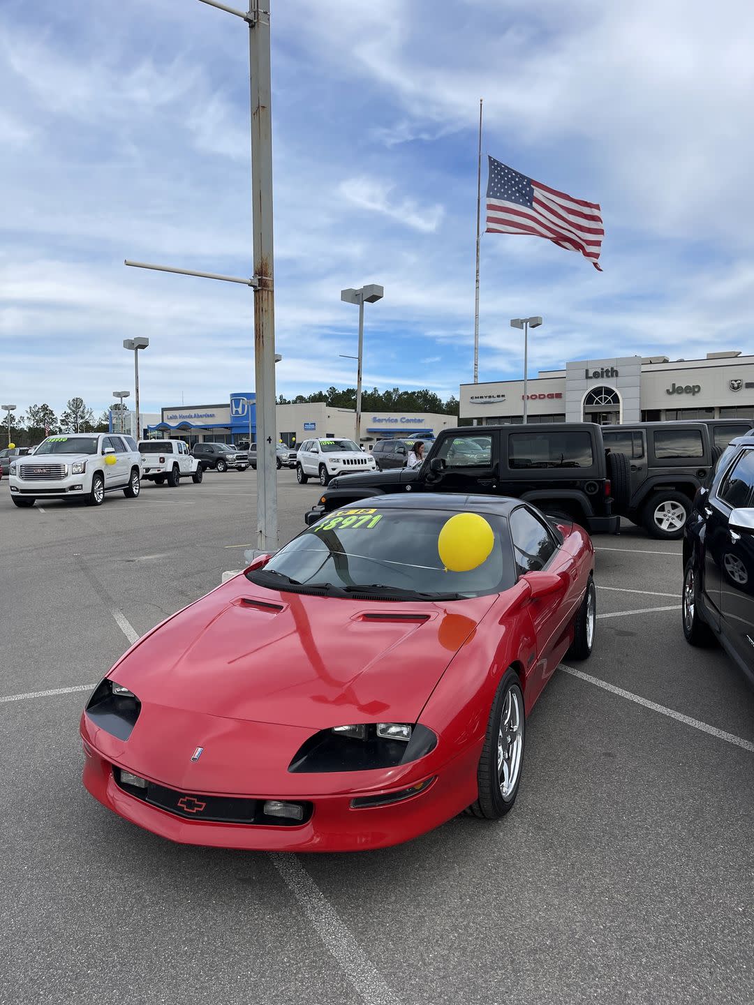 red 90s camaro on a dealer lot