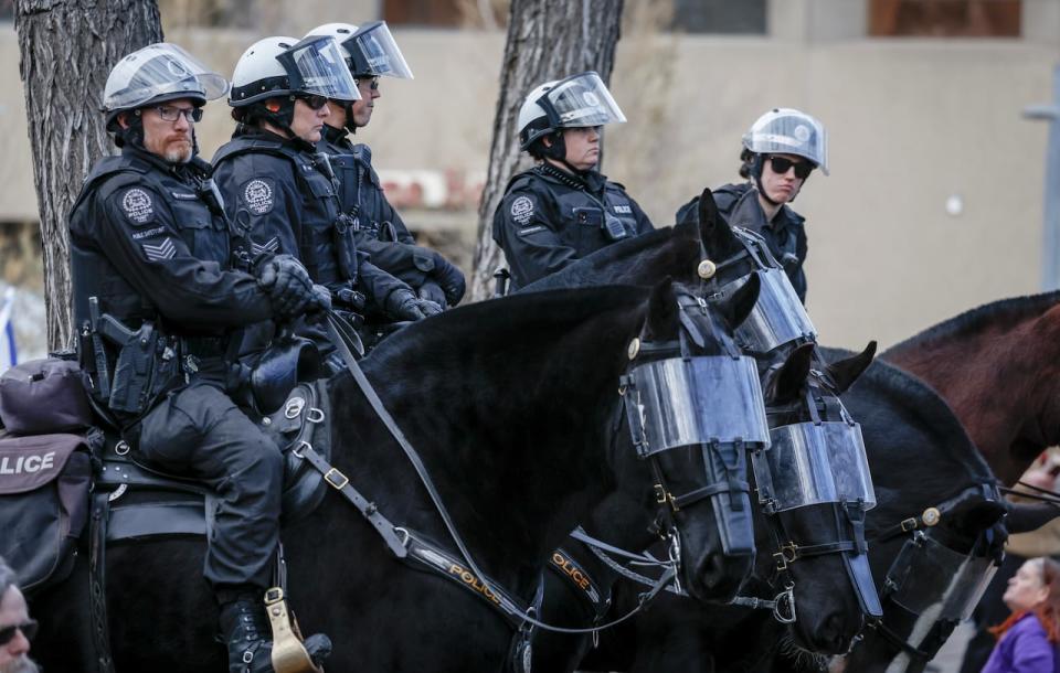 Members of the Calgary Police Service's mounted unit look on at a pro-Palestine rally in Calgary last November. Police Chief Mark Neufeld told city council that they are seeing a rise in the number of protests in the city.  (Jeff McIntosh/The Canadian Press - image credit)