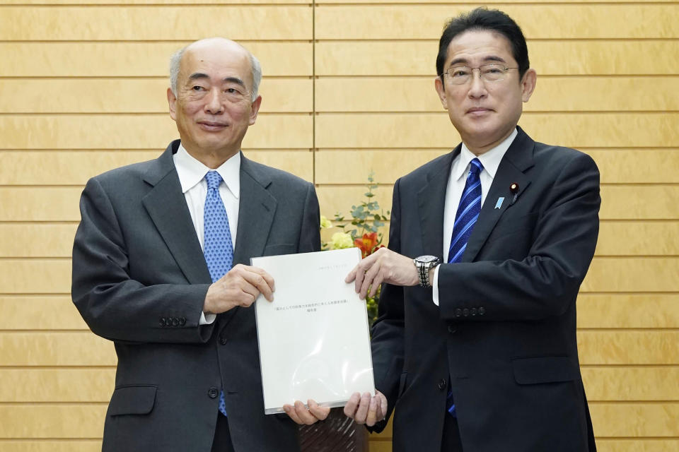 Japan's Prime Minister Fumio Kishida, right, and former ambassador to the U.S. Kenichiro Sasae pose for a photo at the prime minister's office in Tokyo, Tuesday, Nov. 22, 2022. A Japanese government-commissioned panel said in a report to "indispensable" amid growing threats in the region, calling for the public’s understanding to bear the financial burden for the defense of their country. (Kyodo News via AP)