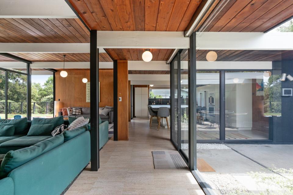 An open air atrium entrance leads to the home's main living areas, where original globe light fixtures dot the tongue-and-groove ceilings.