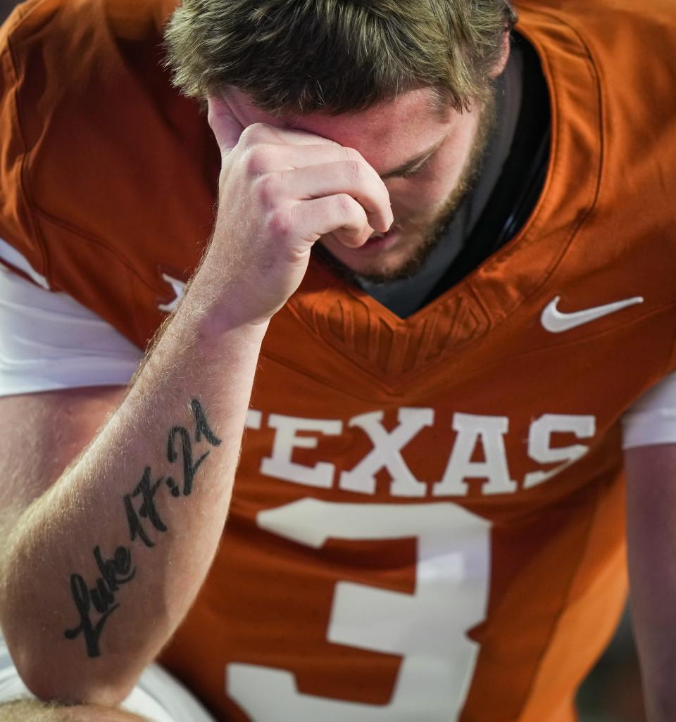 Texas quarterback Quinn Ewers prays ahead of the regular-season finale against Texas Tech on Nov. 24. He said he draws inspiration from the Bible verse Luke 17:21 that's tattooed on his right forearm. "I think it's a powerful, powerful verse," he said Friday.