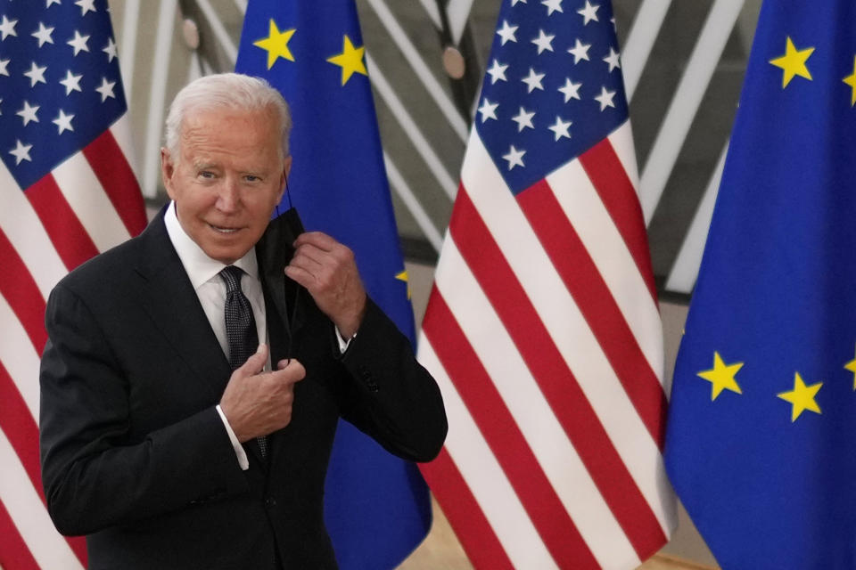 U.S. President Joe Biden takes off his protective facemask prior to speaking with the media during arrival for the EU-US summit at the European Council building in Brussels, Tuesday, June 15, 2021. (AP Photo/Francisco Seco)