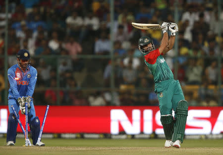 Cricket - India v Bangladesh - World Twenty20 cricket tournament - Bengaluru, India, 23/03/2016. Bangaldes's Mashrafe Mortaza (R) is bowled as India's captain and wicketkeeper Mahendra Singh Dhoni looks on. REUTERS/Danish Siddiqui