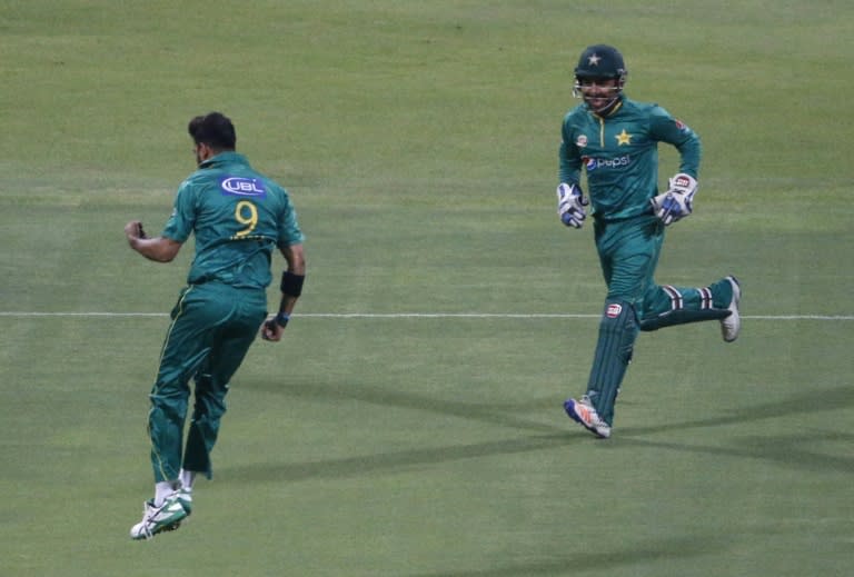 Pakistan's bowler Imad Wasim (L) celebrates with his teammate Sarfraz Ahmed after bolwing out West Indies' Johnson Charles on September 27, 2016