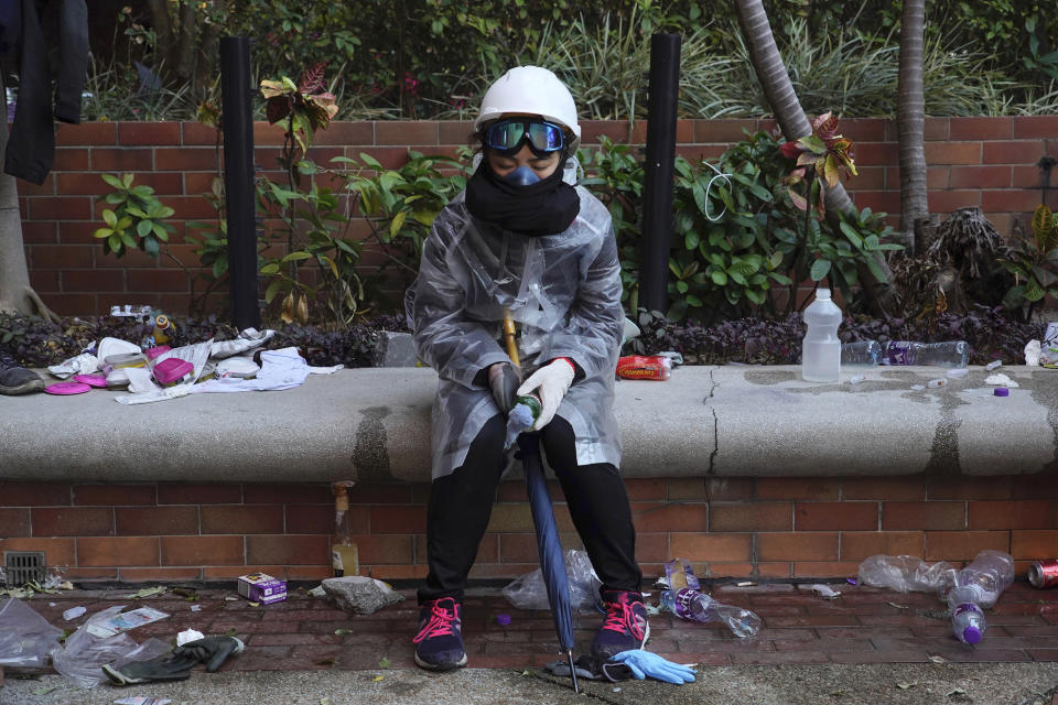 A protester rests at Hong Kong Polytechnic University after police stormed part of the campus during the early morning hours in Hong Kong, Monday, Nov. 18, 2019. Police breached the university campus held by protesters early Monday after an all-night siege that included firing repeated barrages of tear gas and water cannons. (AP Photo/Vincent Yu)