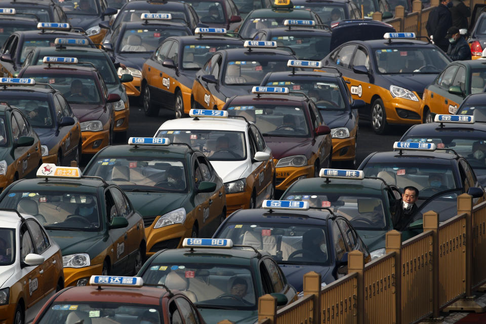 A taxi driver looks out from his car as they pile up to wait for customers at the train station in Beijing, Tuesday, Feb. 11, 2020. China's daily death toll from a new virus topped 100 for the first time and pushed the total past 1,000 dead, authorities said Tuesday after leader Xi Jinping visited a health center to rally public morale amid little sign the contagion is abating. (AP Photo/Andy Wong)