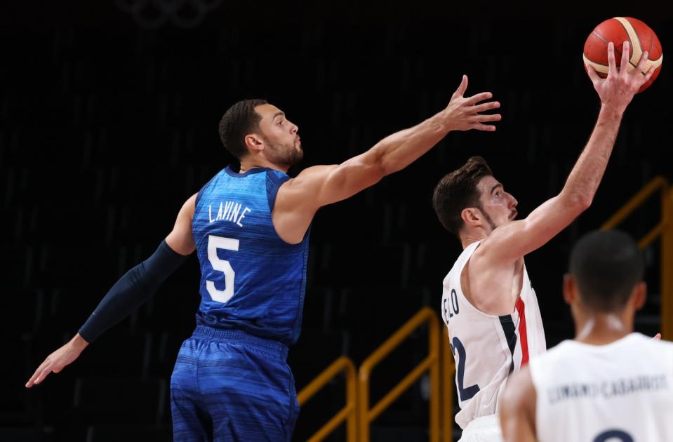 Zach LaVine leaps as Nando de Colo takes the ball to the hoop.