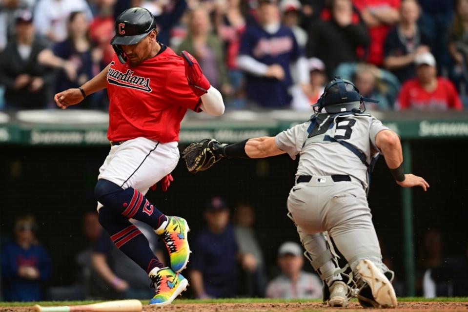 The Guardians’ Josh Naylor, right, scores a run after avoiding a tag by New York Yankees catcher Austin Wells in the 10th inning on April 14. AP