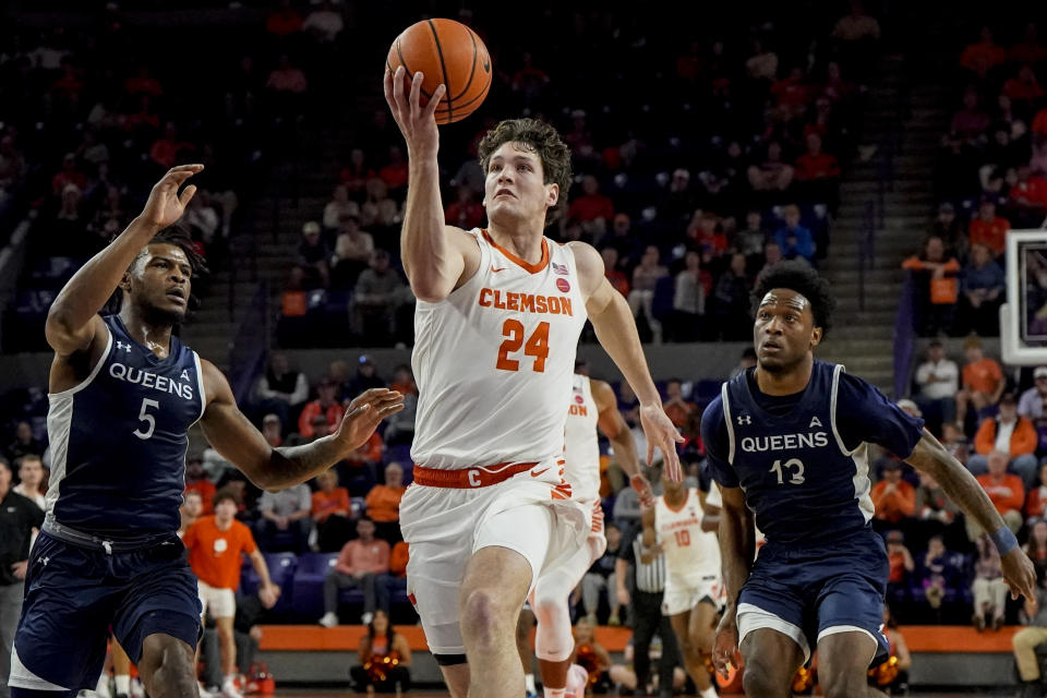 Clemson center PJ Hall (24) heads to the hoop against Queens University guard AJ McKee (5) during the first half of an NCAA basketball game, Friday, Dec. 22, 2023, in Clemson, S.C. (AP Photo/Mike Stewart)