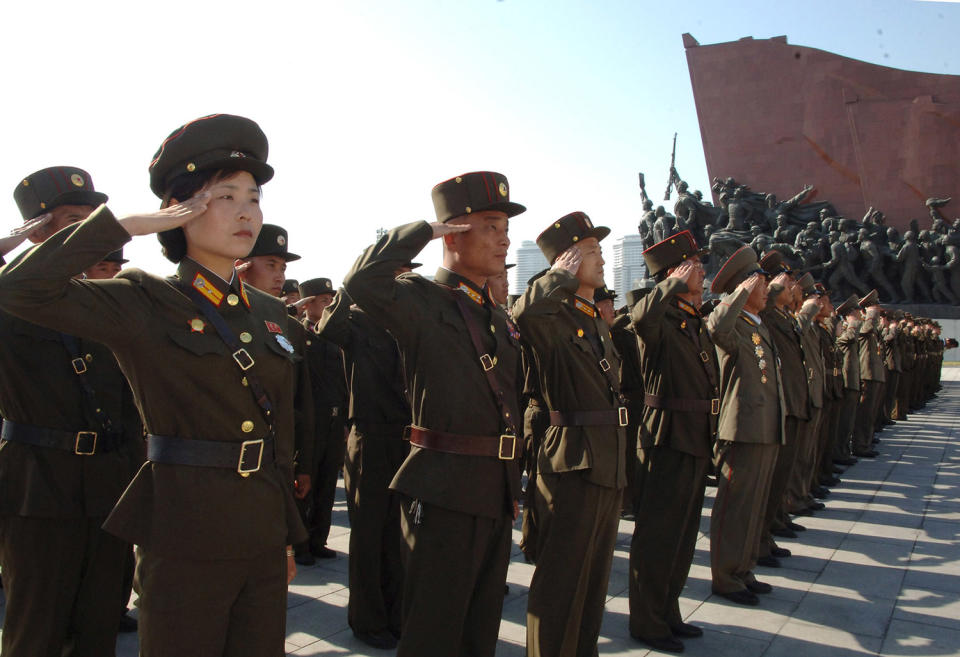 Soldados saludando en la visita a las estatuas de los ex líderes norcoreanos Kim Il Sung y Kim Jong Il