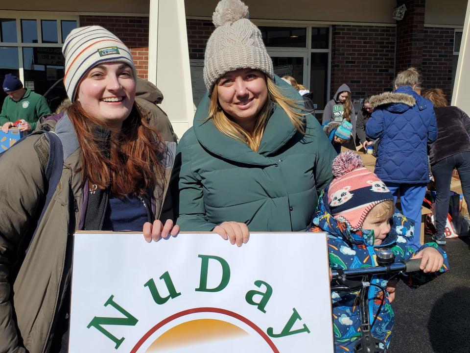 Becky Kuzma and Kateryna Ridley, both with family ties to Ukraine, hold a sign for Nu-Day, the Derry-based relief organization  that will ship the supplies collected by an army of volunteers in Dover on Sunday.