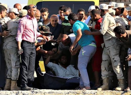 A man reacts as rescue workers carry the body of a victim on a stretcher after a boat carrying migrants capsized off Egypt's coast, in Al-Beheira, Egypt, September 22, 2016. REUTERS/Mohamed Abd El Ghany