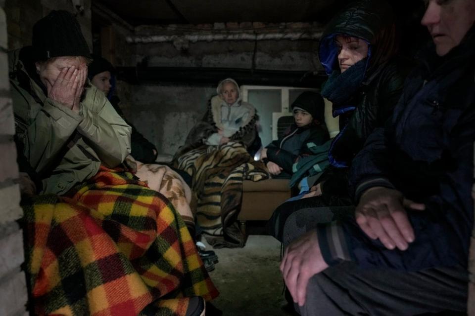 A woman cries in the cellar of a house crowded with people sheltering from Russian airstrikes, outside Kyiv (AP)