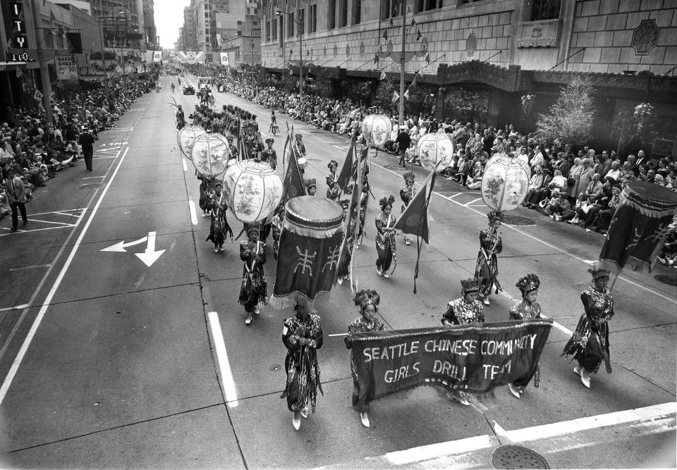 In 1952, the Seattle Chinese Community Girls Drill Team participates in the Seafair Parade for the first time in downtown Seattle. (via Chenanigan Films)