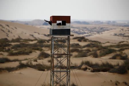 An Egyptian policeman gestures from an observation tower seen from the Israeli side of the border with Egypt's Sinai peninsula, in Israel's Negev Desert in this February 10, 2016 file photo. REUTERS/Amir Cohen/Files