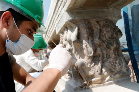 An Egyptian archaeologist works on restoring relief sculptures at the Baron Empain Palace, in the Cairo's suburb Heliopolis