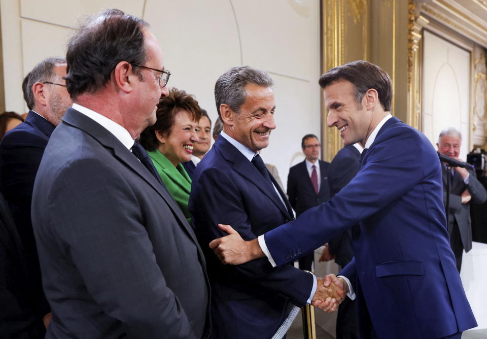 France's former President Francois Hollande, left, looks on as France's former President Nicolas Sarkozy, center, shakes hands with French President Emmanuel Macron during the ceremony of his inauguration for a second term at the Elysee palace, in Paris, France, Saturday, May 7, 2022. Macron was reelected for five years on April 24 in an election runoff that saw him won over far-right rival Marine Le Pen. (Gonzalo Fuentes/Pool via AP)