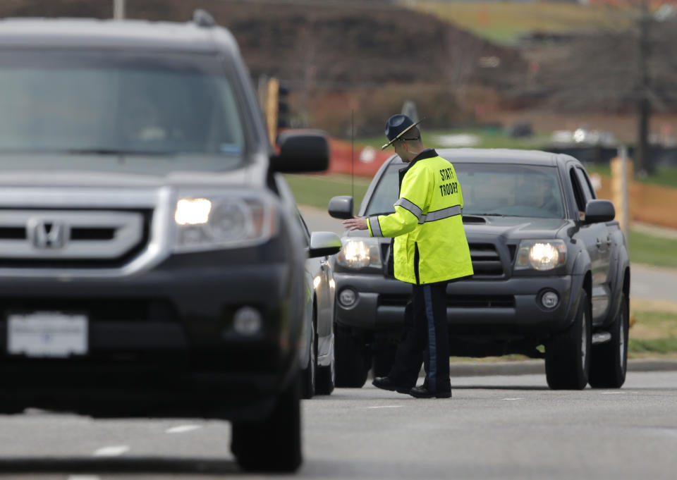 A Kansas State Trooper controls traffic at the entrance of the Jewish Community Center after reports of a shooting in Overland Park, Kan., Sunday, April 13, 2014. (AP Photo/Orlin Wagner)