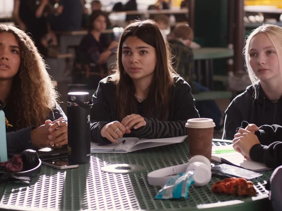 Sasha (Ariana Greenblatt) and her friends sitting at a lunch table in "Barbie."