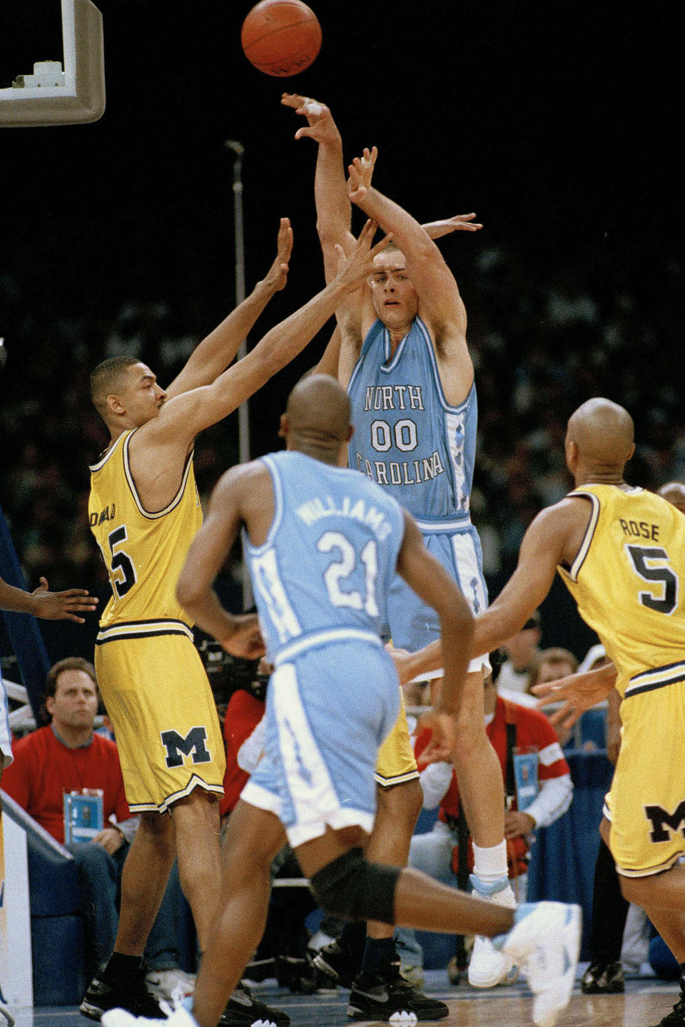 FILE - In this April 5, 1993, file photo, North Carolina's Eric Montross (00) flips a pass over to teammate Donald Williams (21) as Michigan's Juwan Howard covers during the first half of their Final Four NCAA championship game in New Orleans. North Carolina beat Michigan 77-71. (AP Photo/Paul Sancya, File)