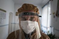 In this photo taken on Friday, May 1, 2020, doctor Ivan Venzhynovych, wearing special suit to protect against coronavirus, poses for a photo after morning examination patients with coronavirus at a hospital in Pochaiv, Ukraine. Ukraine's troubled health care system has been overwhelmed by COVID-19, even though it has reported a relatively low number of cases. (AP Photo/Evgeniy Maloletka)